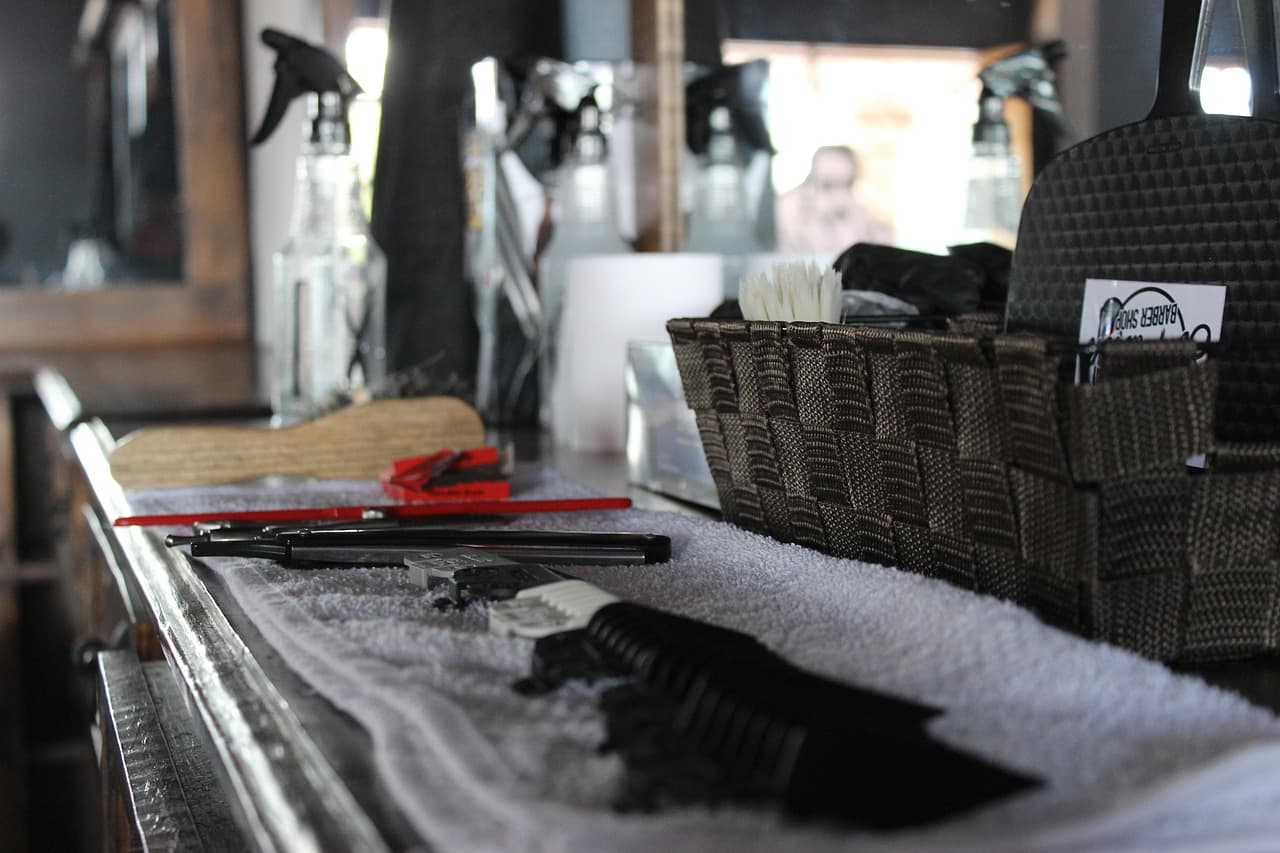Folded towels, sprays and tools laid out along a barber’s station